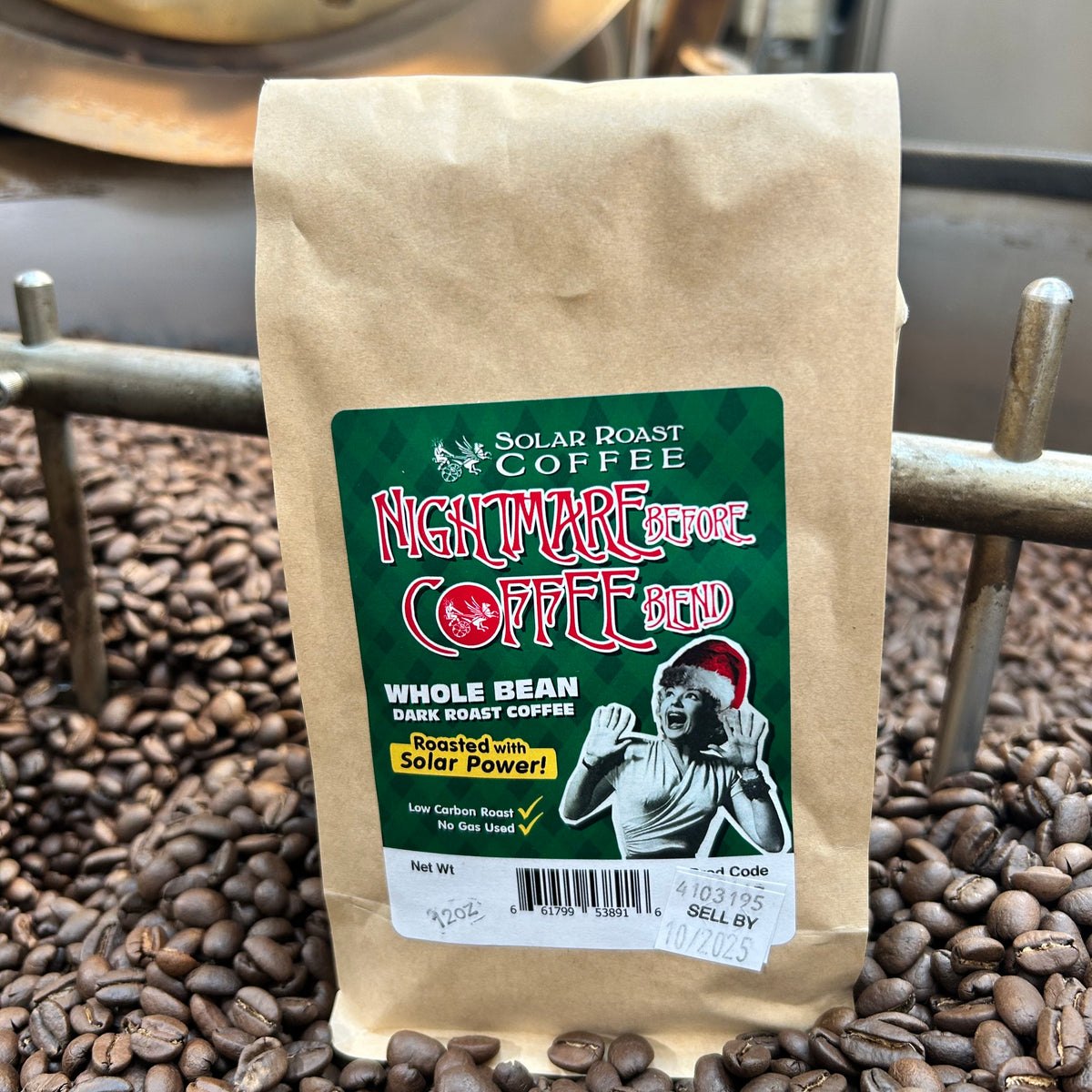 A bag of Nightmare Before Coffee Blend sitting in fresh roasted beans in the Solar Roast cooling tray